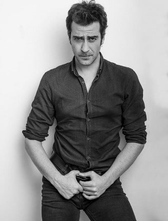 Erhan Alpay posing for a picture by wearing black shirt and black jeans.